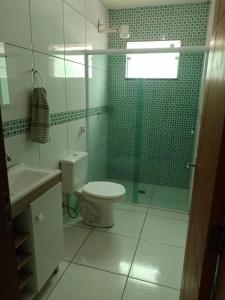 a bathroom with a toilet and a glass shower at Casa Ampla em Boituva-SP in Boituva +30 photos