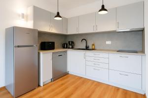 a kitchen with white cabinets and stainless steel appliances at Peninsula Apartment in Žuljana +5 photos