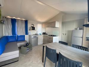 a kitchen with a table and a dining room at Mobil-home Premium Côte d'Azur Camping 4 étoiles Saint-Raphaël Piscines Climatisation Vue mer et Parking in Saint-Raphaël