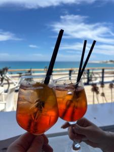 two people holding drinks with the beach in the background at South Italy summer house in Stazione di San Sostene