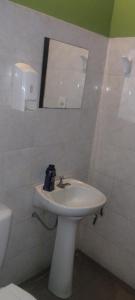 Un baño blanco con lavabo y espejo. en Hospedaje24hs, en Argentina