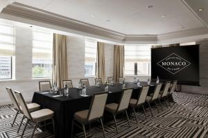 a conference room with a table and chairs and a screen at Kimpton Hotel Monaco Baltimore Inner Harbor by IHG in Baltimore