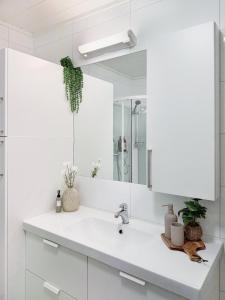 a white bathroom with a sink and a mirror at The gateway to Senja in Senja +21 photos