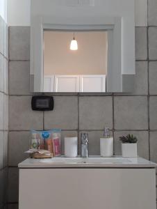 a bathroom counter with a sink and a mirror at Kairòs - locazione turistica in Torre Annunziata