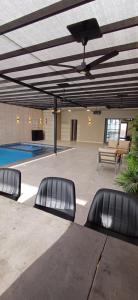 a swimming pool with three empty chairs in a building at LAVA Resort Hot spring water in Mukāwir