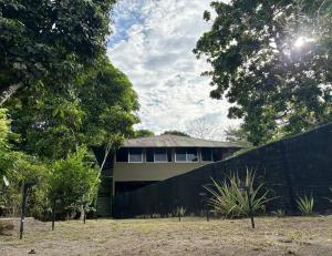 a house behind a fence in a yard at Peregrine Nest Puerto Jimenez in Puerto Jiménez