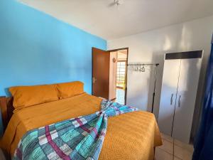 Un dormitorio con una cama con una manta encima. en Residencial Santinho, en Florianópolis