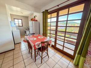 una cocina con una mesa y un refrigerador en Residencial Santinho, en Florianópolis