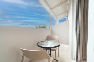 a small table and chairs in a room with a window at Zante Apts in Laganas