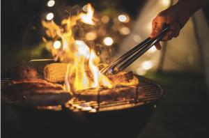 a person is cooking food on a grill at Ocean View Agat Marina Private Accommodation in Agat