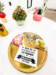 Una mesa cubierta con un plato con un cartel. en La Placita Boutique Trinidad, en Málaga