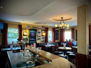 a restaurant with a bar and people sitting at tables at Hotel zu den Linden in Wachtberg