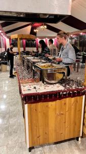 a buffet line with people preparing food in a restaurant at CAPITAL RUM lUXURY CAMP in Wadi Rum +95 photos