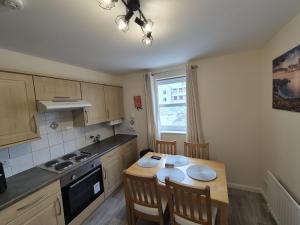 a kitchen with a table and a table and chairs at Spacious Modern 2-BR Apartment in Aberdeen City Centre in Aberdeen