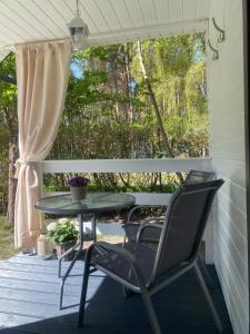 a patio with a table and chairs on a deck at Domki Letniskowe Jarek in Rowy