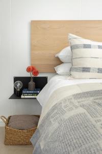 a bedroom with a bed with a wooden headboard at The Braemar - Cape 8 Collection in Cape Town
