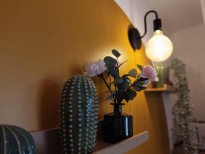 a vase with flowers on a shelf next to a lamp at Dousserença in Bressols