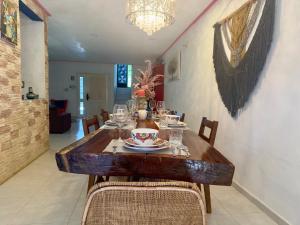 a dining room with a wooden table and chairs at Casa La Perla del Sur Confort y calidez en todos sus espacios in Ticul