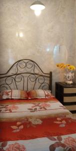 une chambre avec un lit et un vase de fleurs sur une table dans l'établissement Acuarela del Rio H#3 Cerca Aeropuerto y Terminal Habitación privada con baño, à Guayaquil