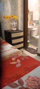 une salle de bain avec un lit et un vase avec des fleurs dans l'établissement Acuarela del Rio H#3 Cerca Aeropuerto y Terminal Habitación privada con baño, à Guayaquil