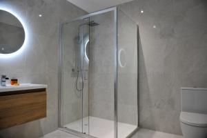 a glass shower in a bathroom with a toilet at The Pier Portrush in Portrush +14 photos