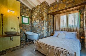 a bedroom with a bed and a tub and a sink at Mediterraneo Luxury Suites Halkidiki in Vourvourou