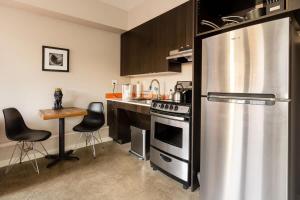 a kitchen with a stainless steel refrigerator and a table at Bright Studio Apartment - Food Carts & Local Shops in Portland