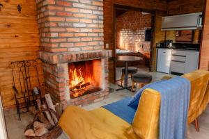 a living room with a fireplace and a couch at Cabanas Ouro do Vale - Pôr do Sol in Bento Gonçalves