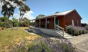 a small house with a bench in a yard at Havelock North Holiday Park in Havelock North