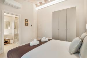 ein weißes Schlafzimmer mit einem großen Bett und zwei Handtüchern in der Unterkunft GOLDEN LUXE - Diamond in the Hills piscina privata e vasca idromassaggio in Serravalle Pistoiese + 57 Fotos