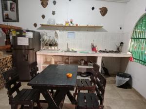 a kitchen with a table and chairs and a refrigerator at CASA BLANCA Hostal in Minca +20 photos