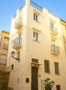 a white building with a black door and balconies at Almar Living - Signature Apartments in Taranto