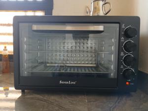 a black toaster oven with its door open at La Résidence du GABOU in Kédougou