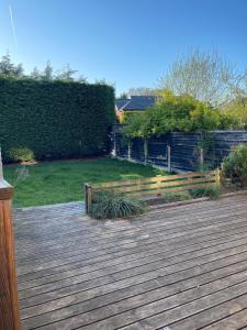 a wooden deck with a fence and a yard at Spacious 3 bed with driveway in Manchester