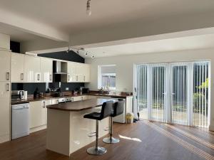 a large kitchen with white cabinets and a counter at Spacious 3 bed with driveway in Manchester