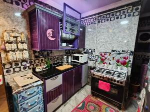 a kitchen with purple cabinets and a stove at نايل كانتري حلوان in ‘Ezbet el-Auqât