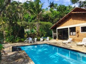 a swimming pool in front of a house at Pousada Romântica Serra da Mata in Penedo