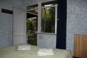 1 dormitorio con ventana y toallas en la cama en Green Hostel, en Dilijan 5 fotos más