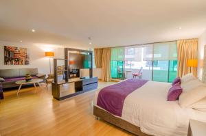 a bedroom with a large bed and a living room at Hotel Grand Park in Bogotá