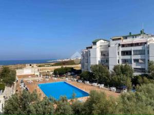 バーリにあるLussy Beach House Rifugio sul mare Casatuabariの建物の前にプールがあるホテル