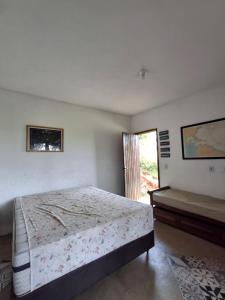 Casa em Buzios MATO - PRAIA في بوزيوس: غرفة نوم بيضاء مع سرير ونافذة