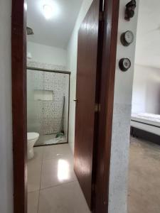 Casa em Buzios MATO - PRAIA في بوزيوس: حمام مع مرحاض وباب خشبي