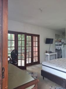 Casa em Buzios MATO - PRAIA في بوزيوس: غرفة نوم بسرير وابواب زجاجية منزلقة