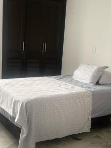 a bed with white sheets and pillows on it at Apartamento amoblado in Neiva