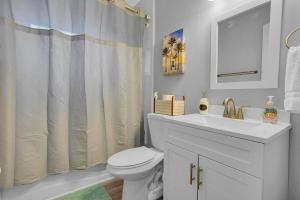 une salle de bain blanche avec un lavabo et des toilettes dans l'établissement SMV Cute Jacksonville Bungalow Central, à Jacksonville 34 autres photos