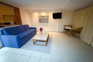 een woonkamer met een blauwe bank en een tafel bij Beach and Pool Access! in Puerto Vallarta
