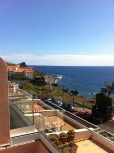 a view of the ocean from the balcony of a building at Ventur Flat in Caniço
