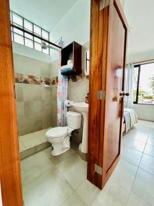 Un baño con inodoro, ducha y lavabo. en Apartment with balcony and access to terrace, en Puerto Ayora