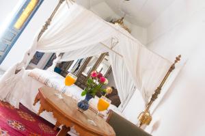 a room with a bed with two glasses of orange juice at Riad Ifoulki in Marrakesh