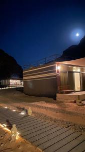 a train traveling past a building at night at مخيم خيال رم in Jurf ad Darāwīsh